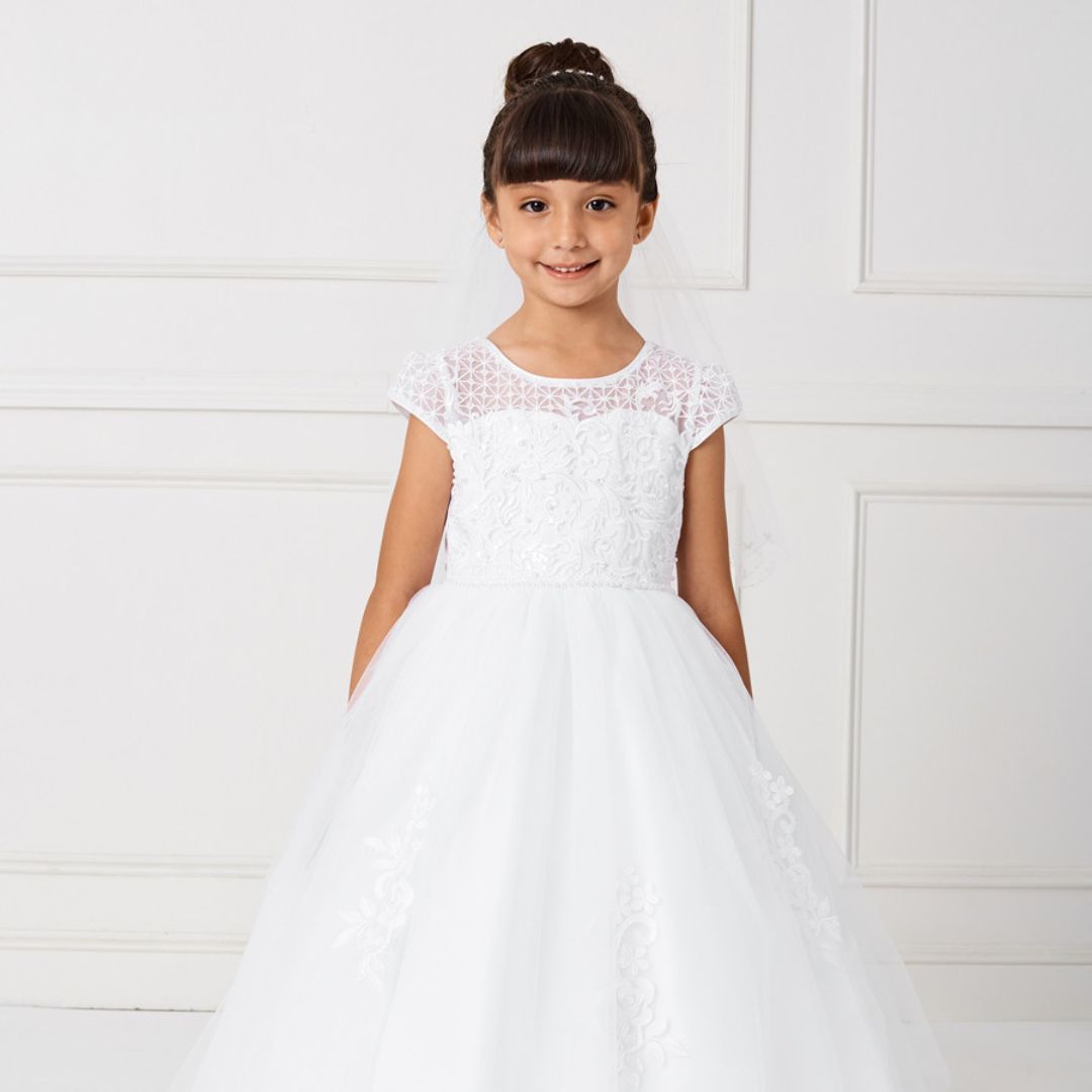 a little girl in a lacy communion dress